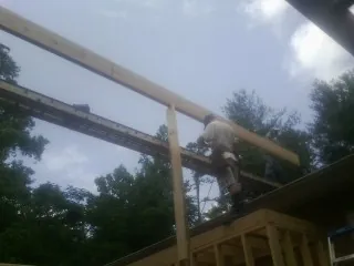 Carpenter setting a ridge beam over a new addition frame — Ice Dam Removal by Roofing Brothers in Newville