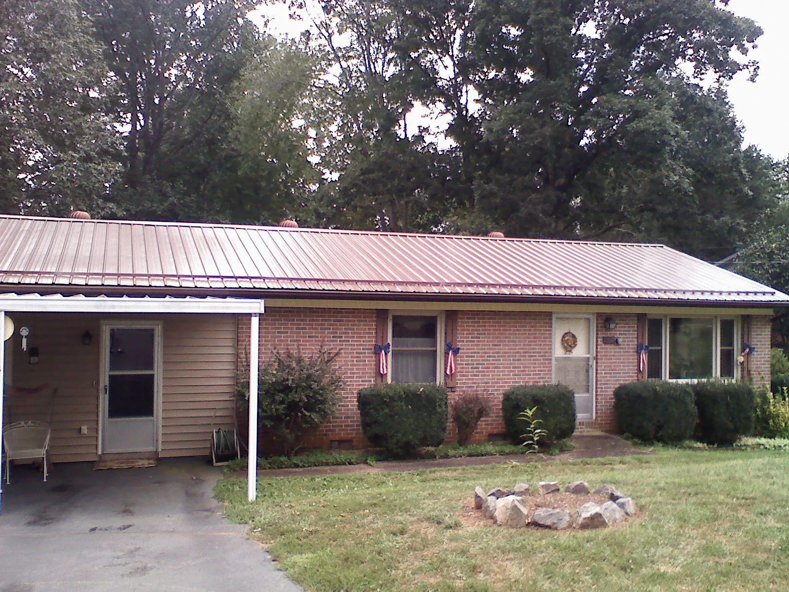 Bronze metal roof and carport on a brick ranch home — Roof Repair work by our crew in Newville